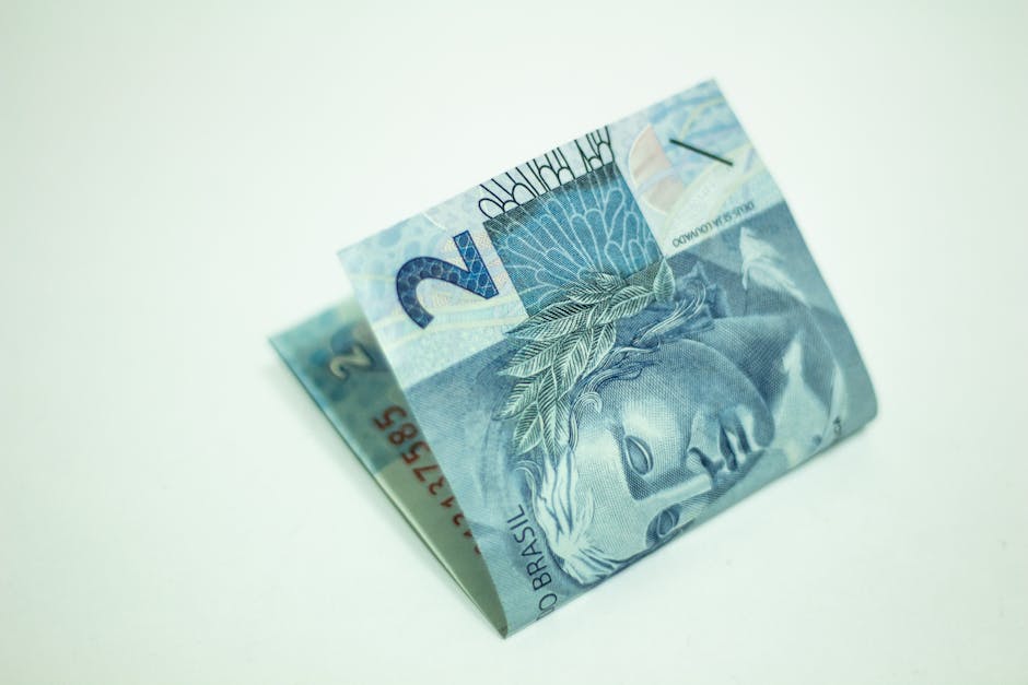 Brazilian real banknotes and laptop on desk