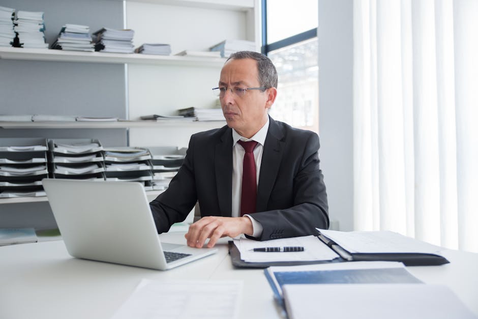 business owner reviewing security alerts on laptop at office
