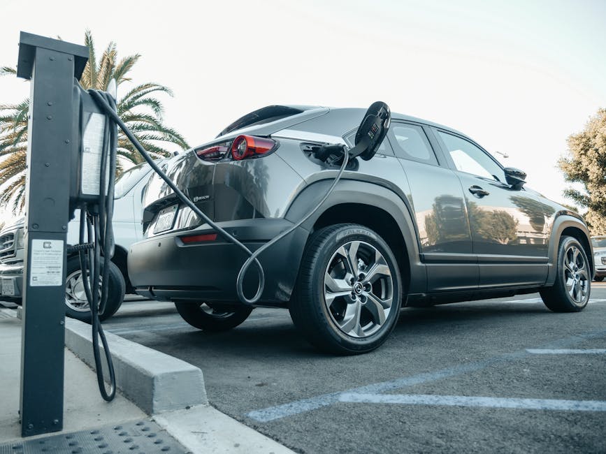 electric car plugged into charging station at night