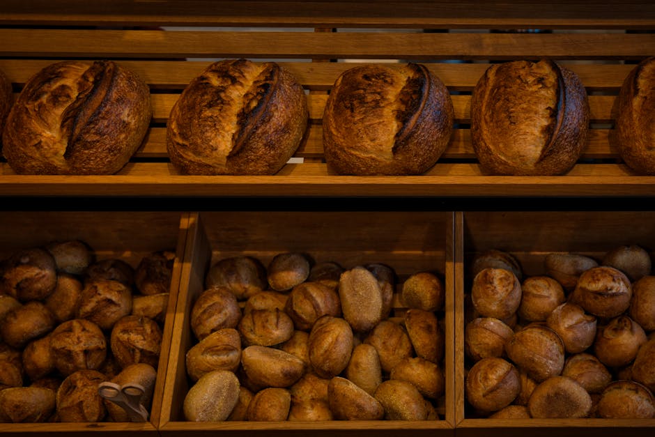 German baker displaying different bread loaves in bakery shop