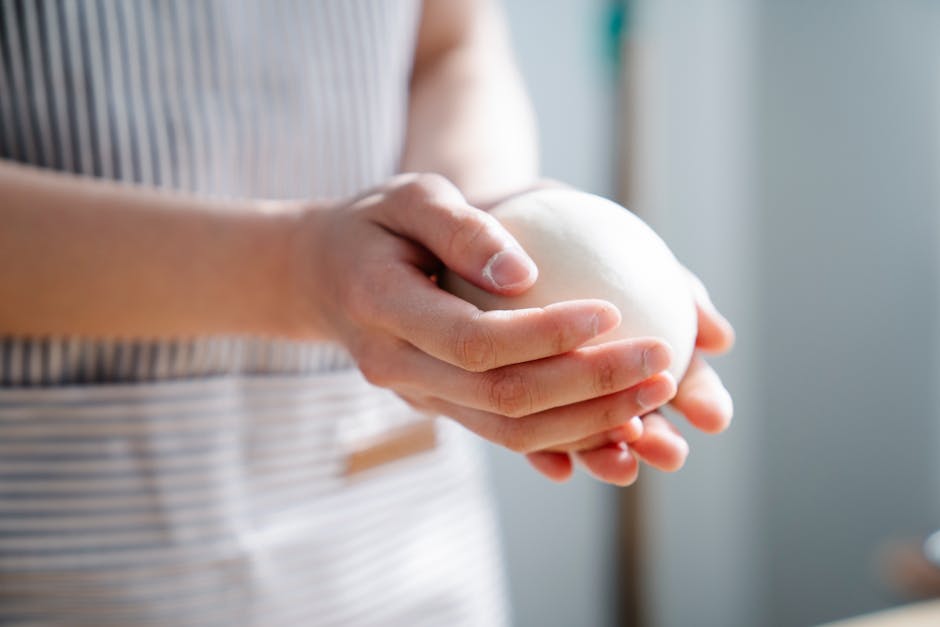 hands shaping tapioca dough balls in kitchen
