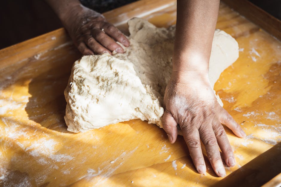 home cook kneading dough on floured surface