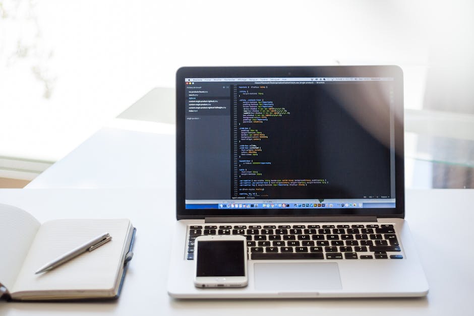 laptop displayed on desk with notepad