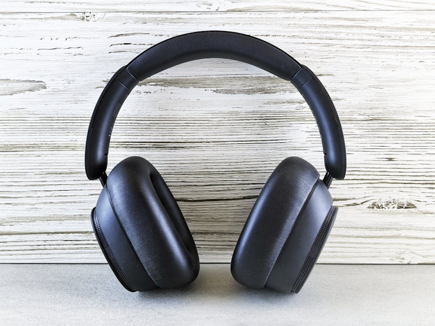 noise cancelling headphones flat lay with accessories on wooden desk