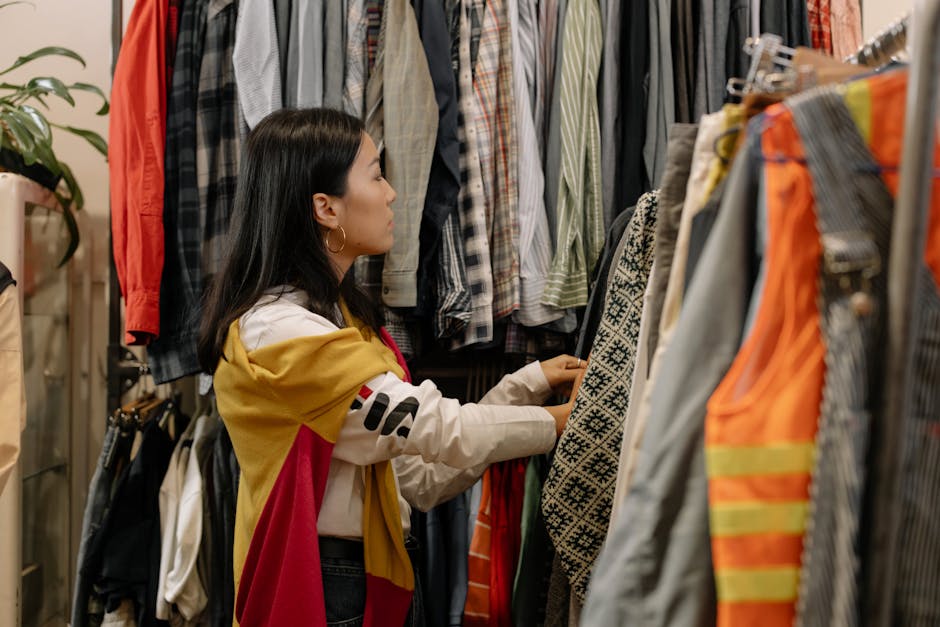 person browsing racks of second-hand clothing in a store