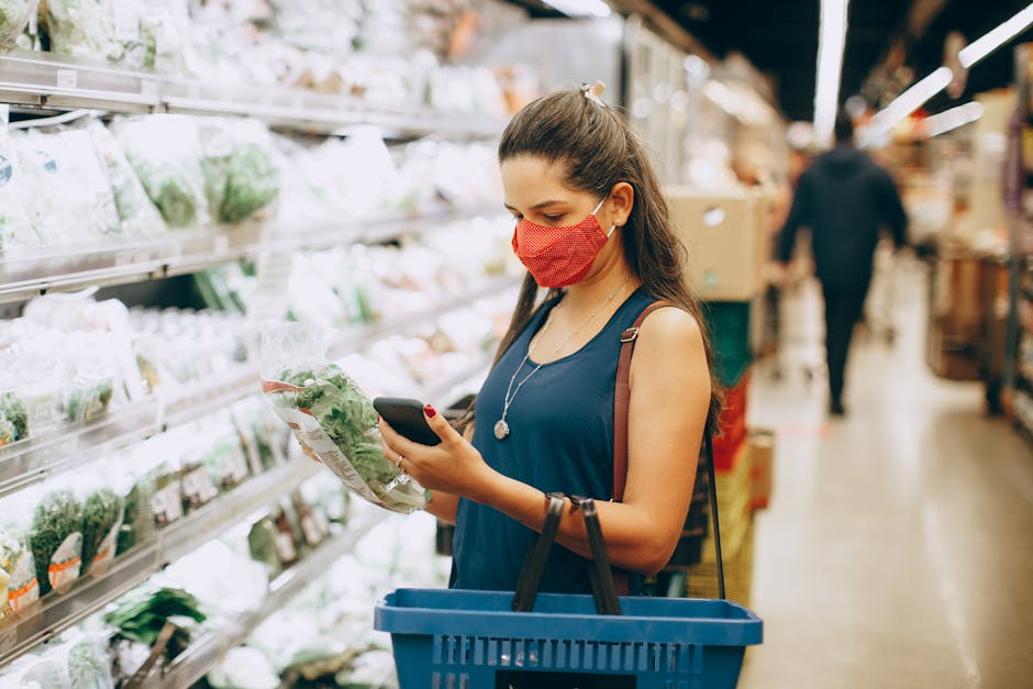 person comparing prices in supermarket with smartphone