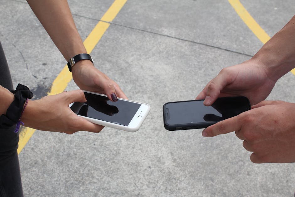 person comparing two smartphone screens