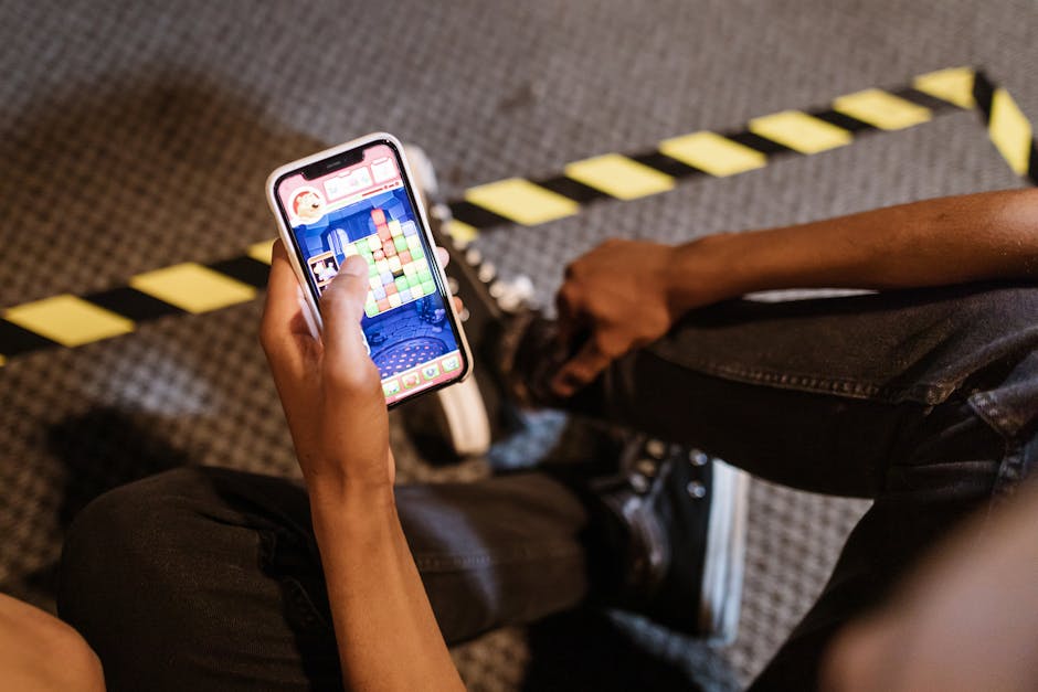 person holding smartphone with gaming apps