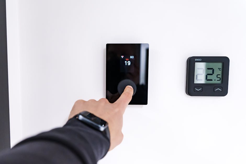 Person installing smart thermostat on wall