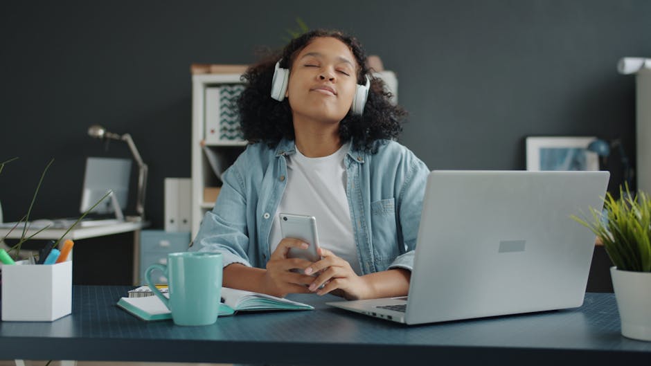 person listening to music with headphones at home office desk