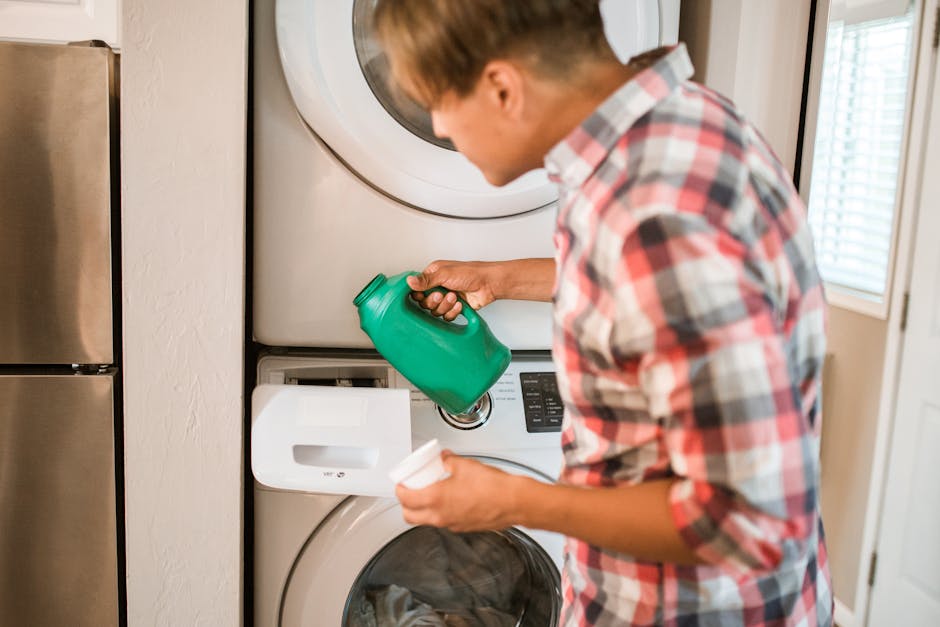 person loading washing machine with laundry detergent