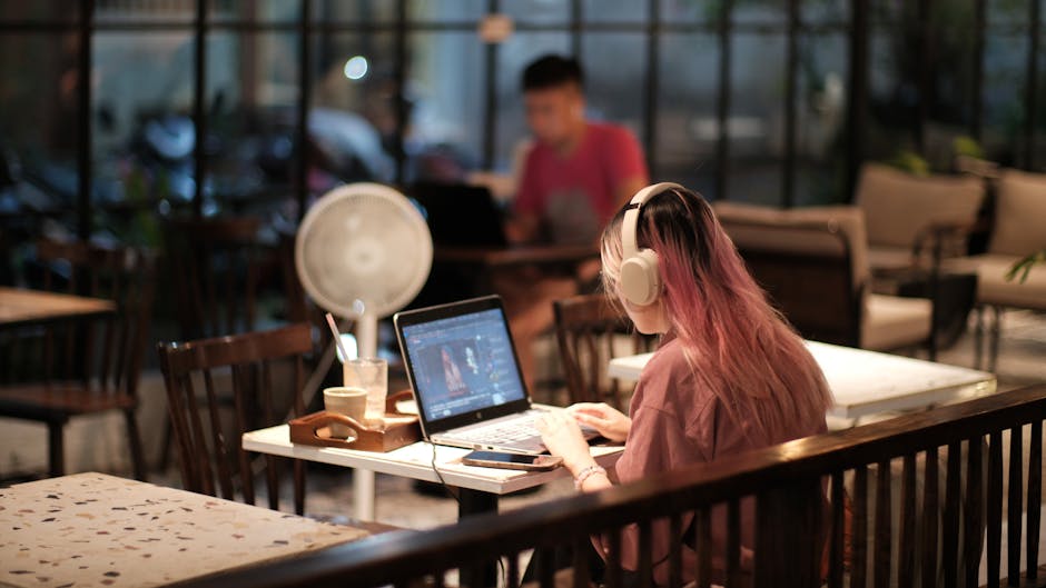 person working with headphones in cafe