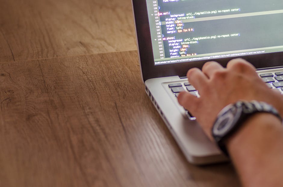 person writing code on computer at desk