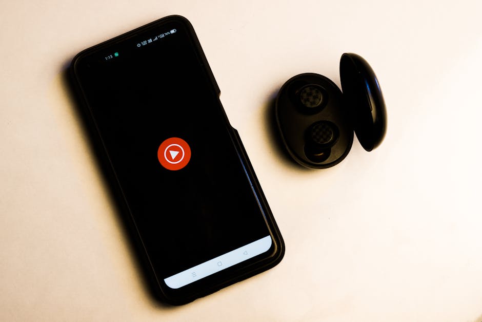 wireless earbuds and phone with music app open