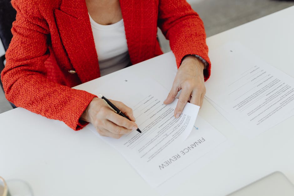 woman signing documents at desk
